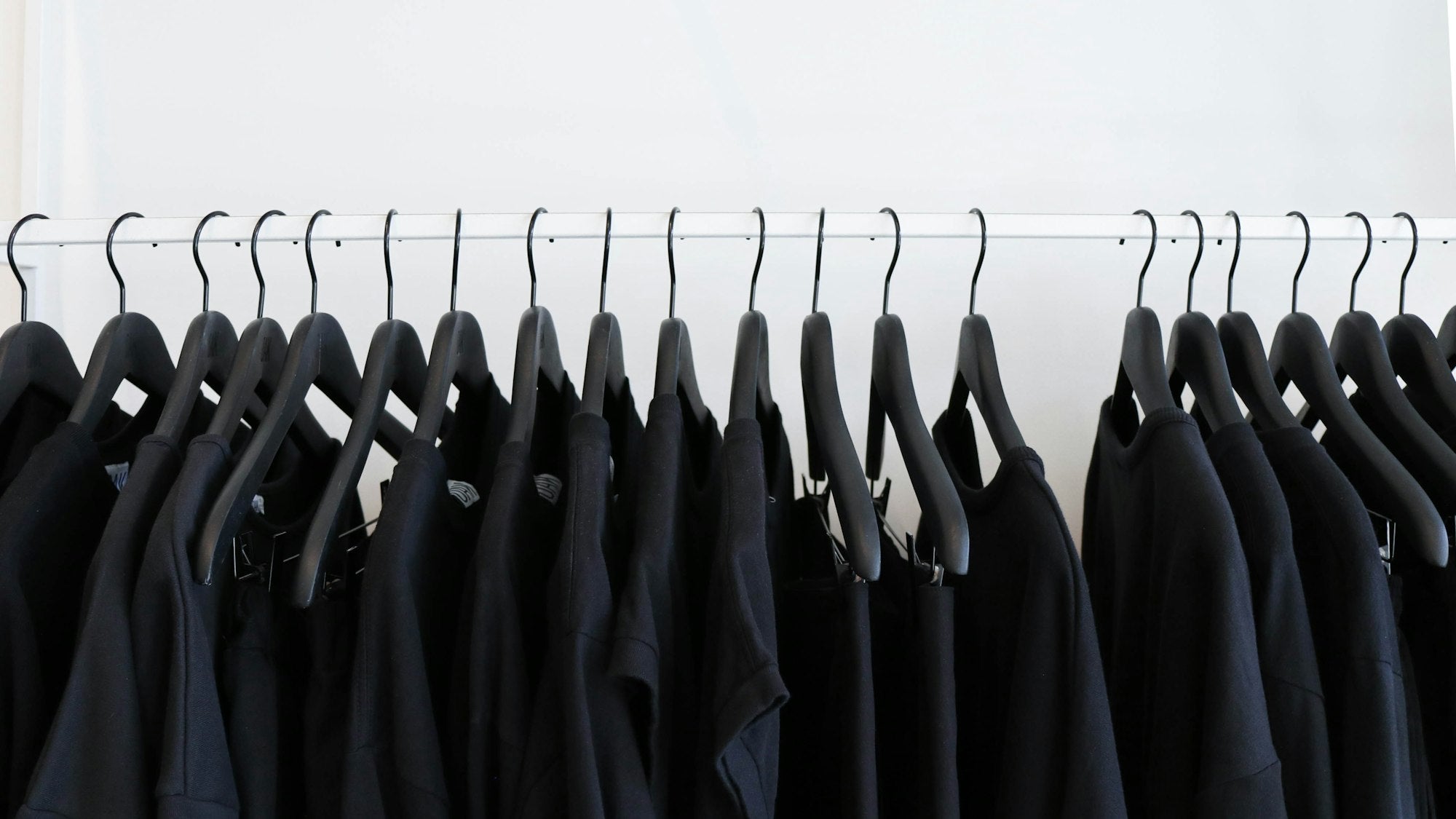 Black shirts hanging on a clothing rail
